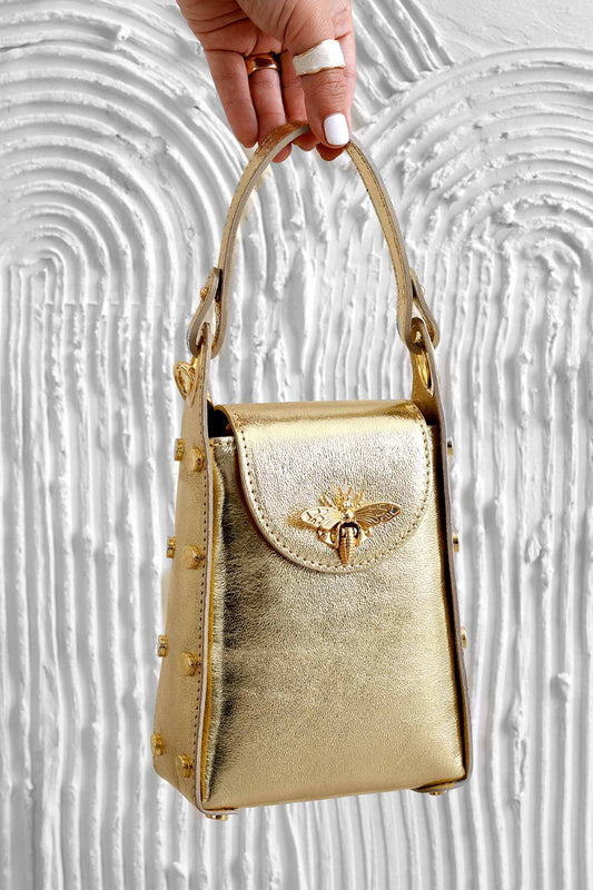 Borsetta oro metallizzata a mano con borchie e tracolla removibile