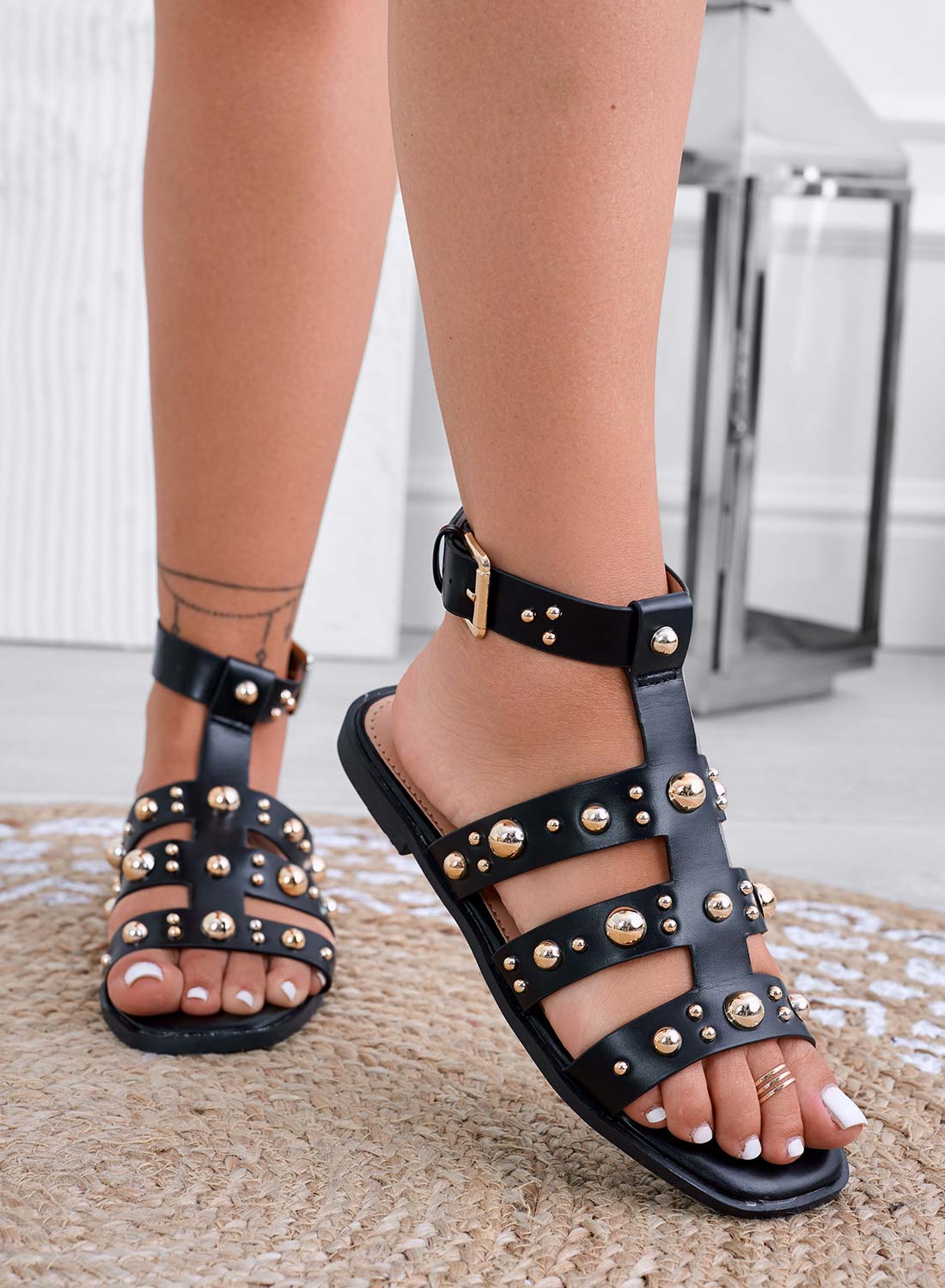 Black flat sandals with gold-studded straps