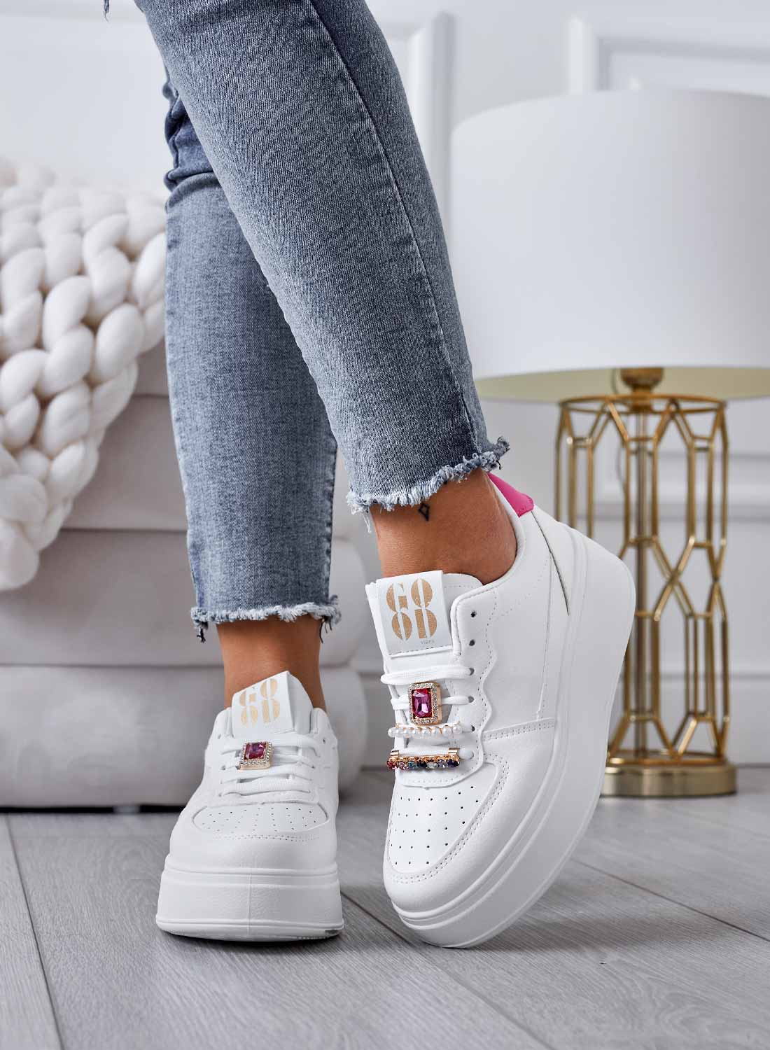 White sneakers with jeweled embellishments and fuchsia heel