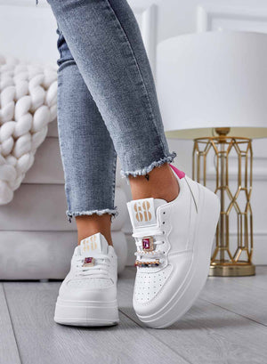 White sneakers with jeweled embellishments and fuchsia heel