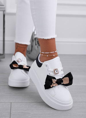 White sneakers with black bow and gold teddy brooch