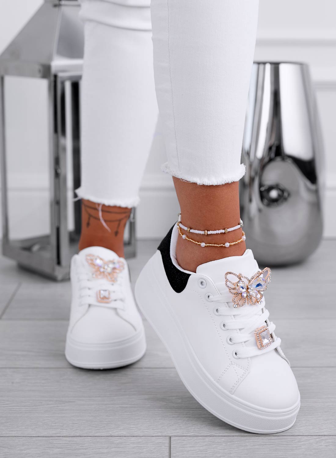 White sneakers with jeweled butterfly applique and black heel
