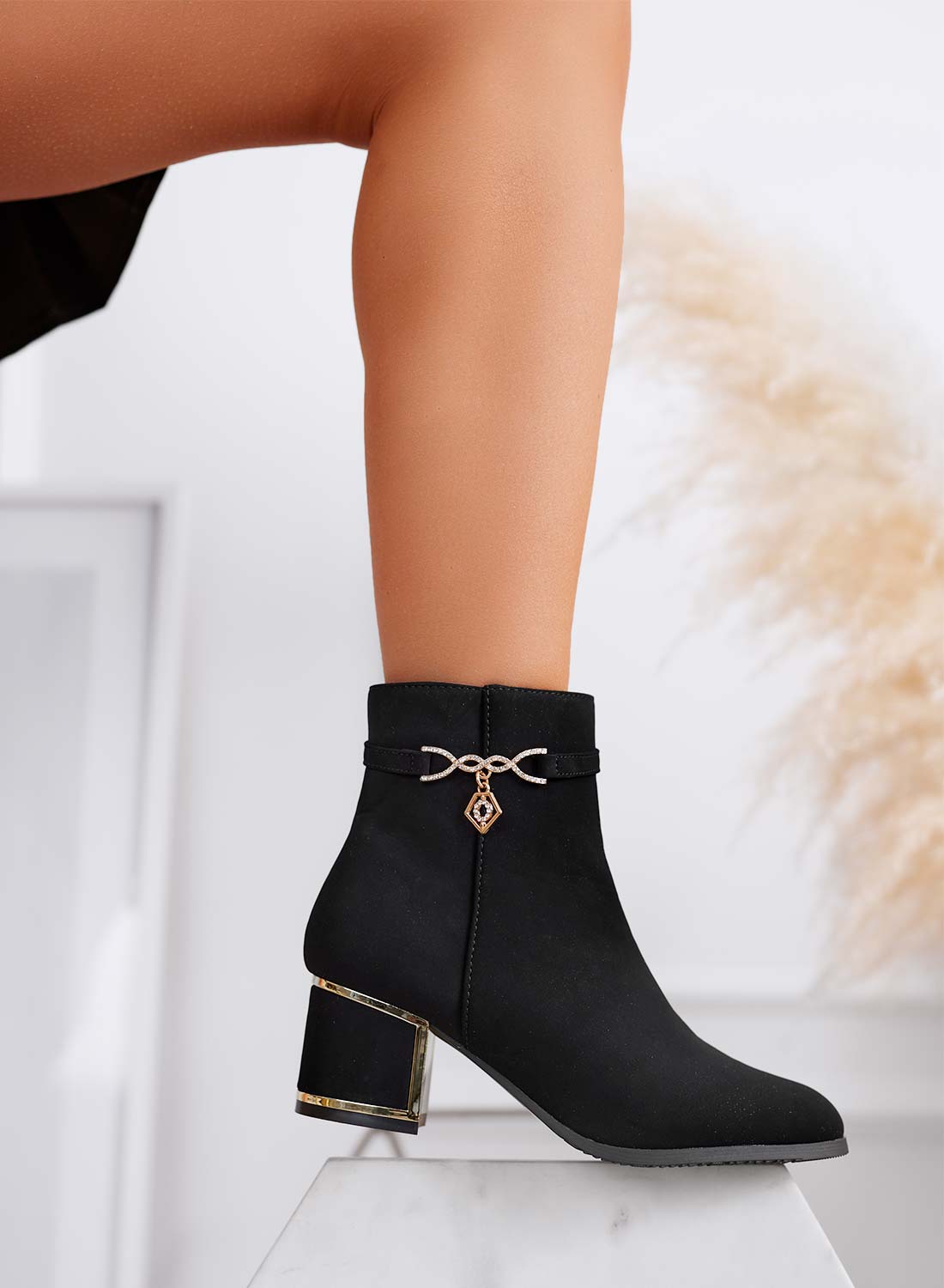Black ankle boots with gold charm