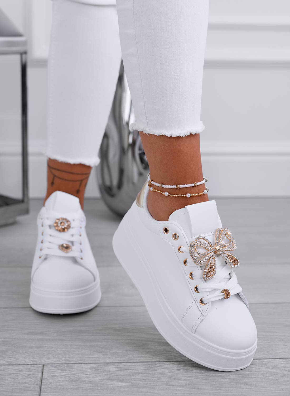 White sneakers with gold jewel bow