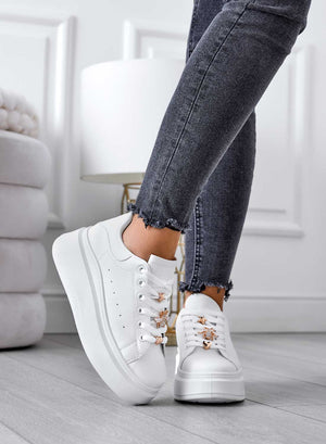 White sneakers with gold details and wedge heel