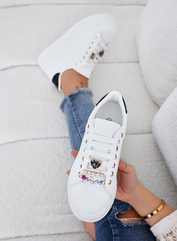 White sneakers with black heel and jewel embellishments