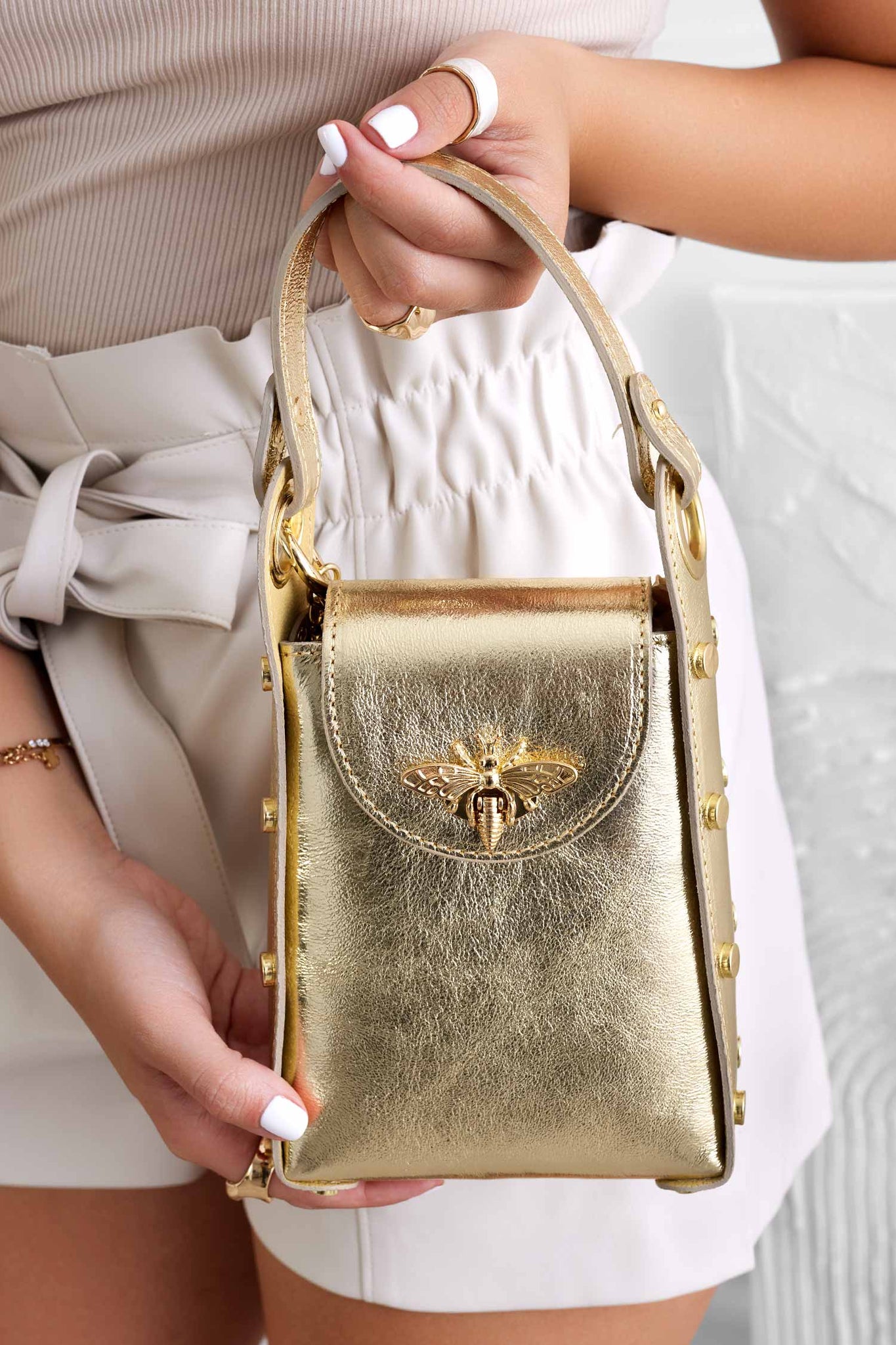 Metallic gold handbag with studs and removable shoulder strap