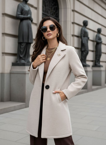 Beige coat with black button and brooch
