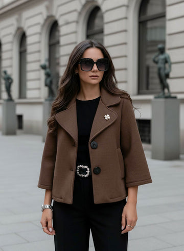 Short brown coat with black buttons and brooch