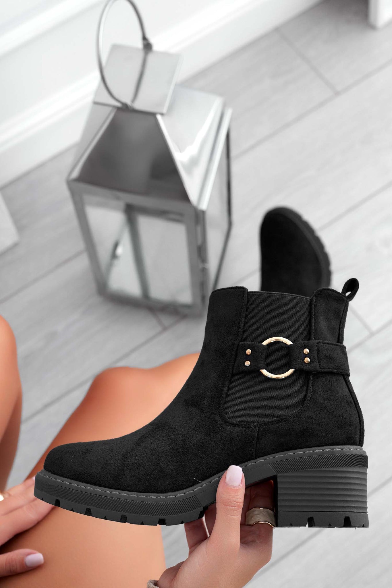 Black suede ankle boots with gold accessory