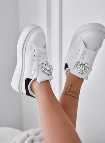 White sneakers with black heel and jewel