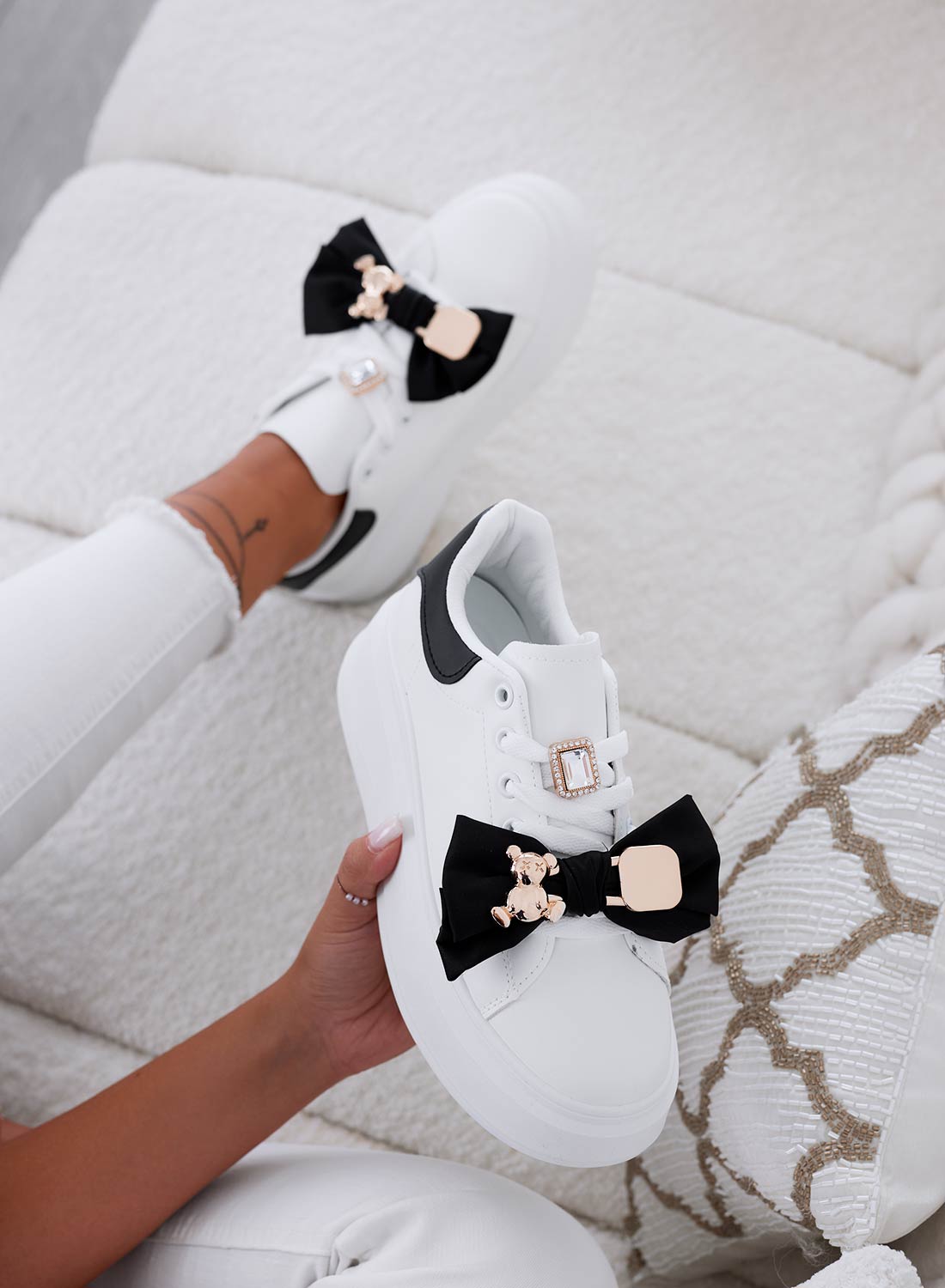 White sneakers with black bow and gold teddy brooch