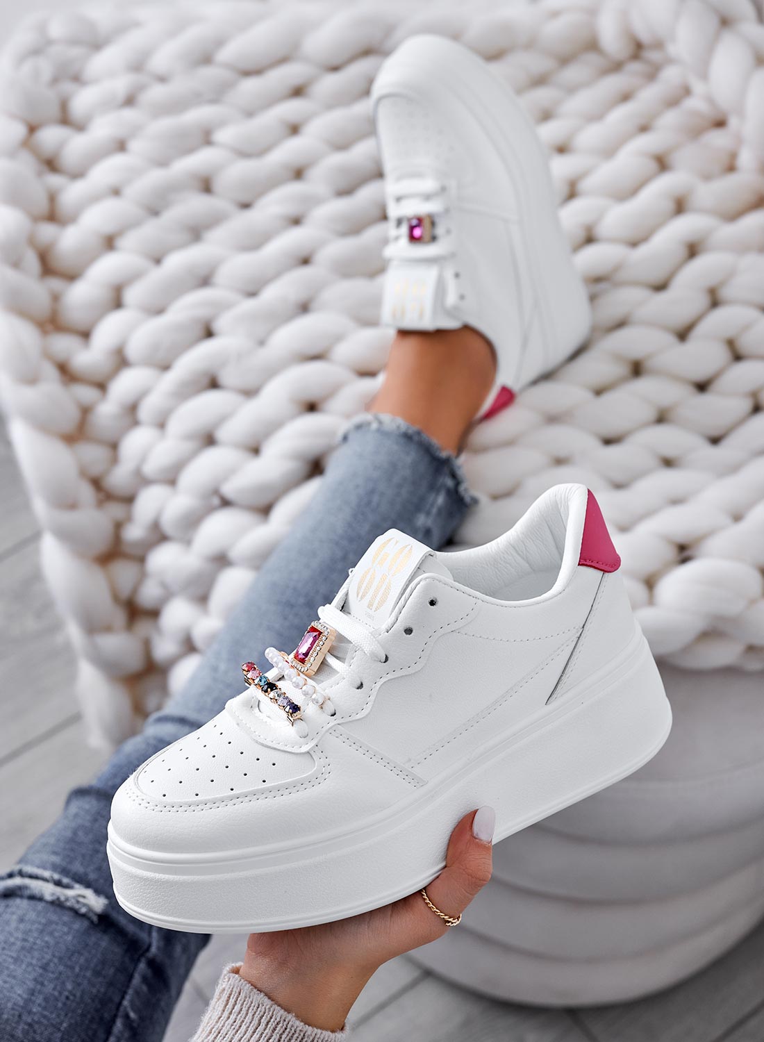 White sneakers with jeweled embellishments and fuchsia heel