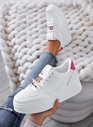 White sneakers with jeweled embellishments and fuchsia heel