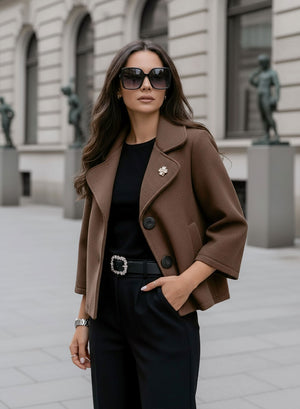 Short brown coat with black buttons and brooch