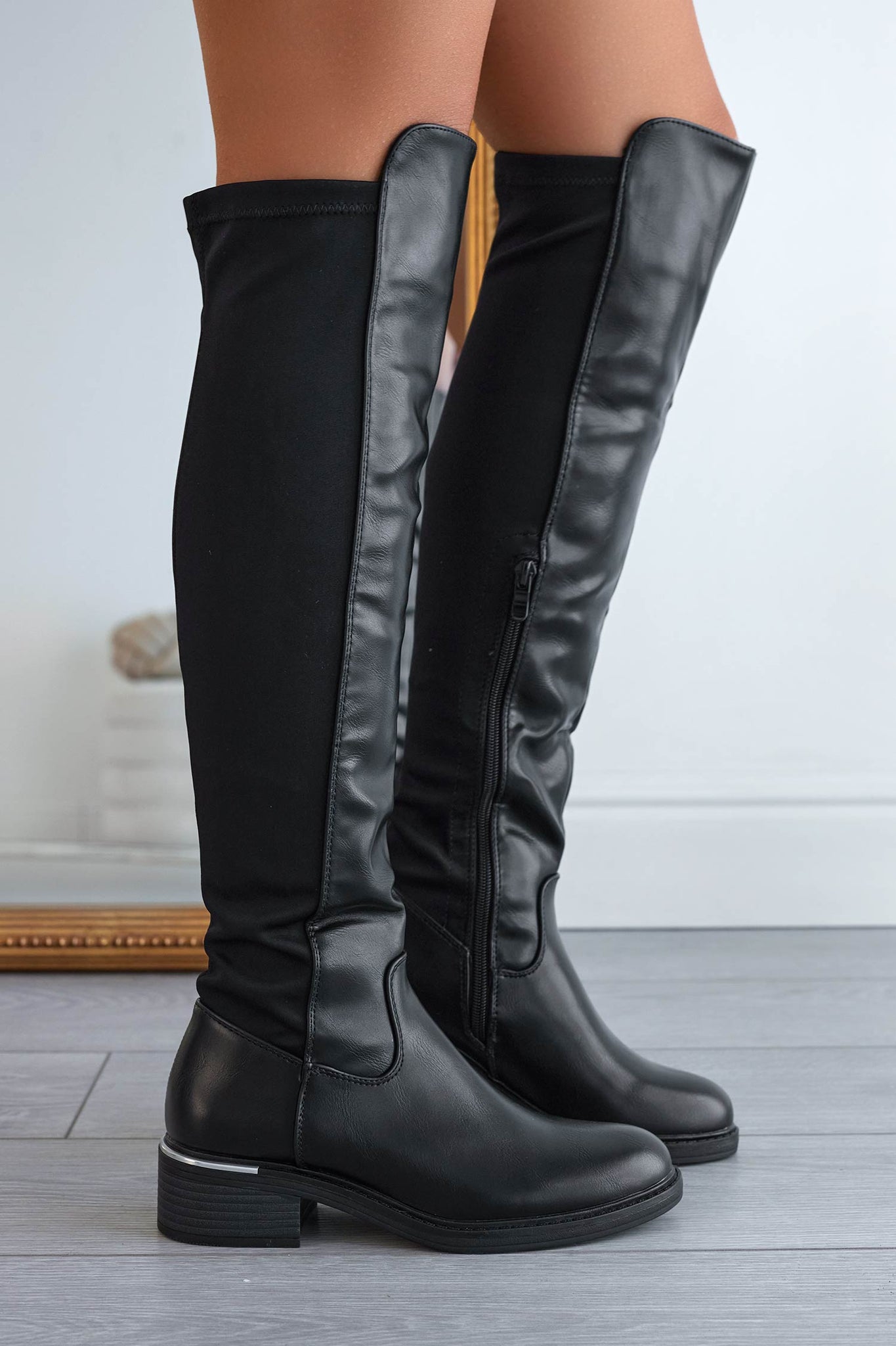 Black over-the-knee boots with stretch fabric at the back