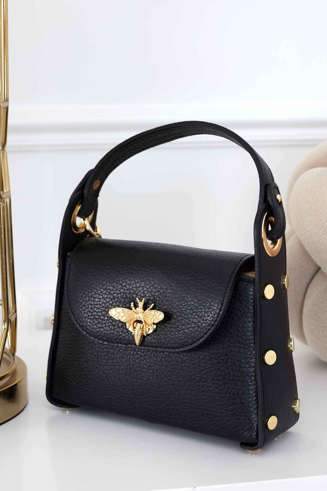 Black handbag with gold studs and removable shoulder strap