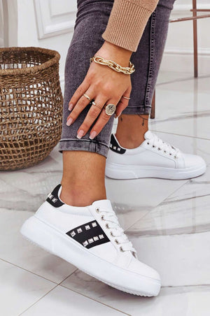 White sneakers with black inserts and studs