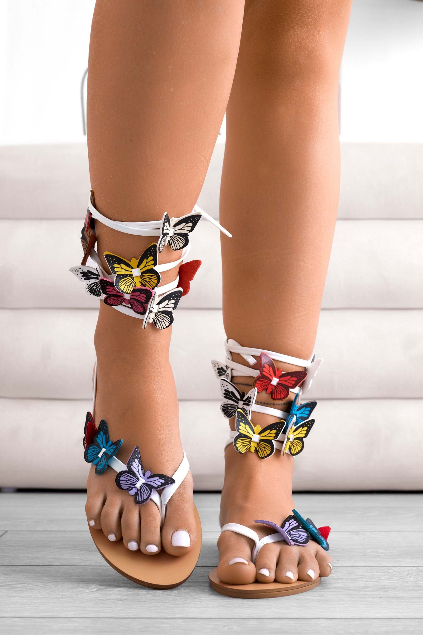 White flat flip-flop sandals with butterfly embellishments