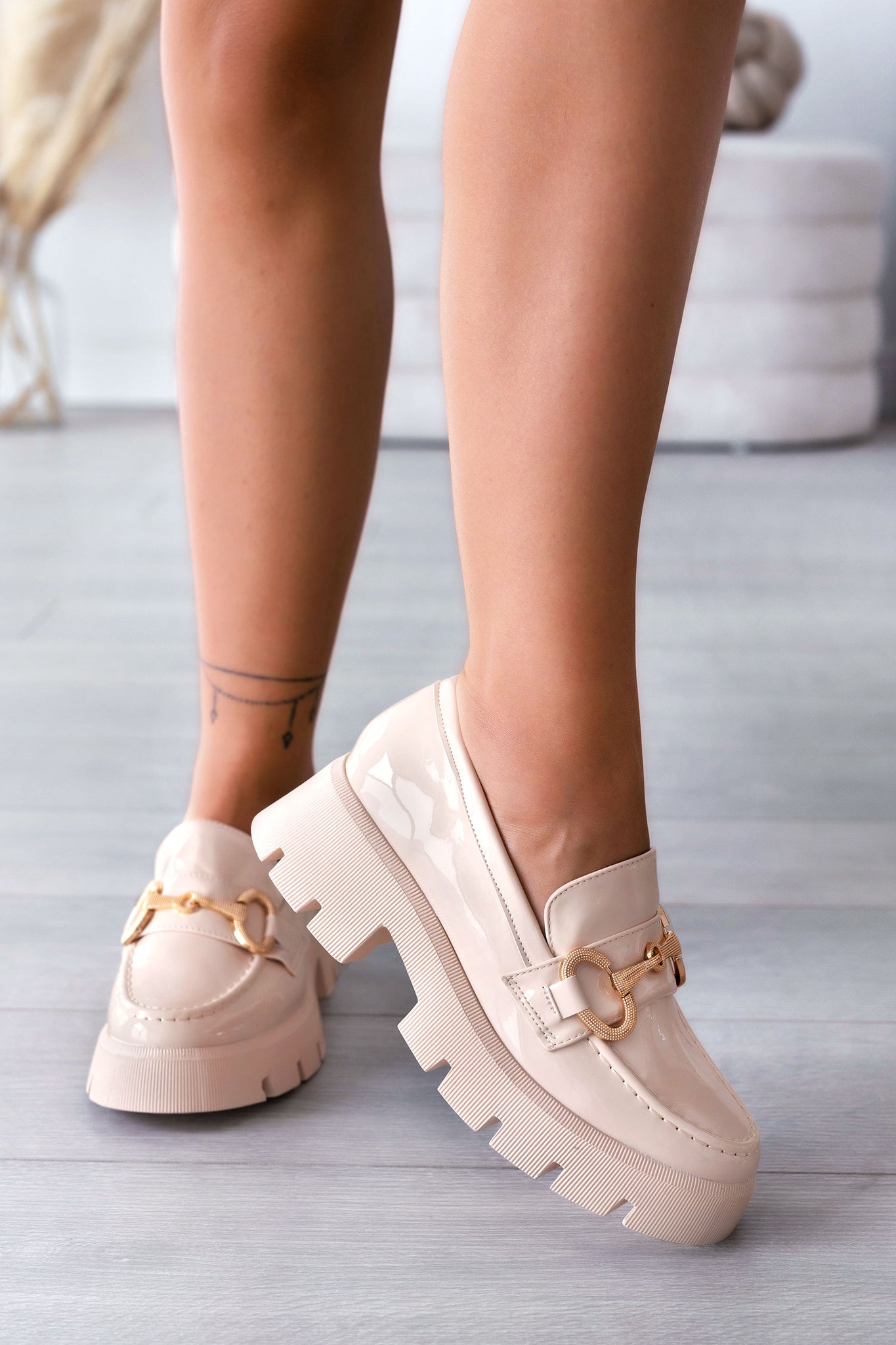 Beige patent loafers with gold buckle